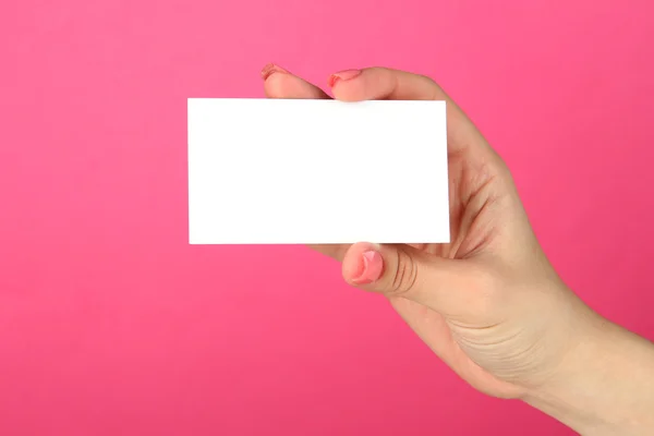 Mão feminina segurando cartão de visita, em fundo de cor — Fotografia de Stock