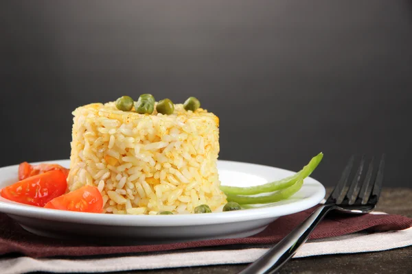 Heerlijke risotto met groenten op houten tafel, op grijze achtergrond — Stockfoto