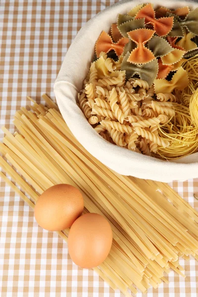 Diversi tipi di pasta su fondo a quadretti — Foto Stock