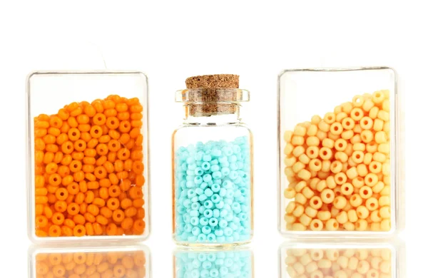 Perline colorate mucchio in scatole e bottiglia di vetro isolato su bianco — Foto Stock
