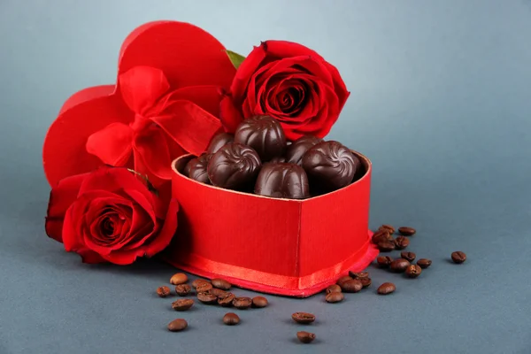 Dulces de chocolate en caja de regalo, sobre fondo gris — Foto de Stock