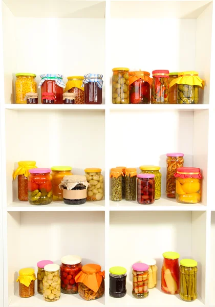 Different conservations on white shelves — 图库照片