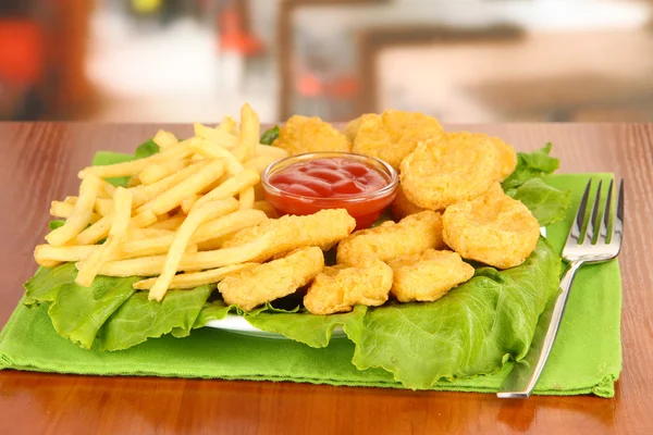 Fried chicken nuggets with french fries and sauce on table in cafe — Stock Photo, Image