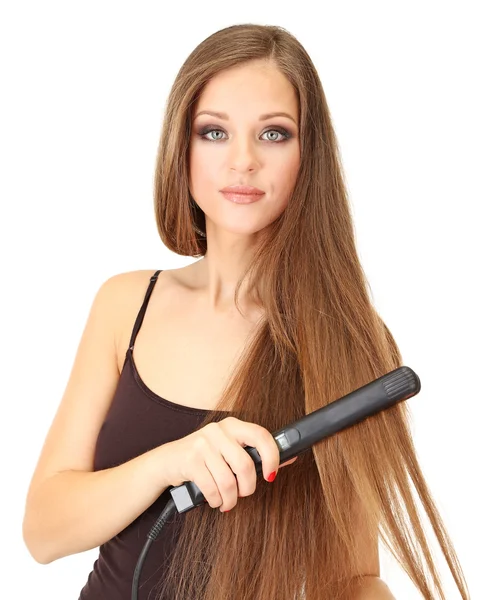 Woman doing hairstyle with hair straightener, isolated on white — Stock Photo, Image
