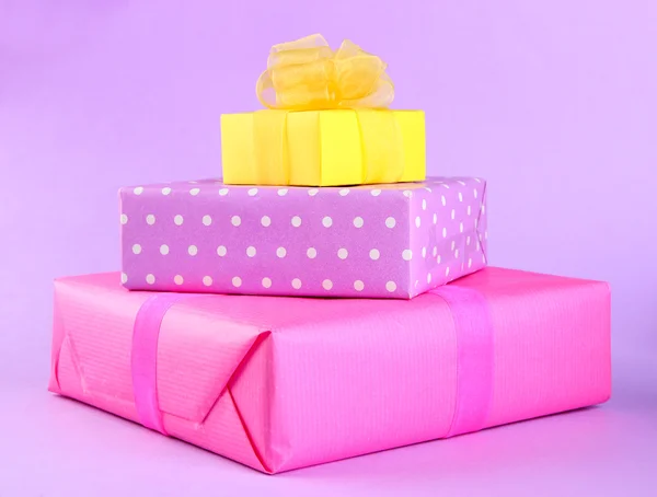 Φωτεινά δώρα με τόξα σε μοβ φόντο — Φωτογραφία Αρχείου
