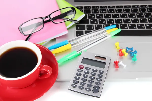 Laptop with stationery and cup of coffee isolated on white — Stock Photo, Image