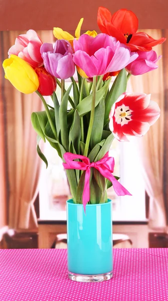 Beautiful tulips in bouquet on table in room — Stock Photo, Image