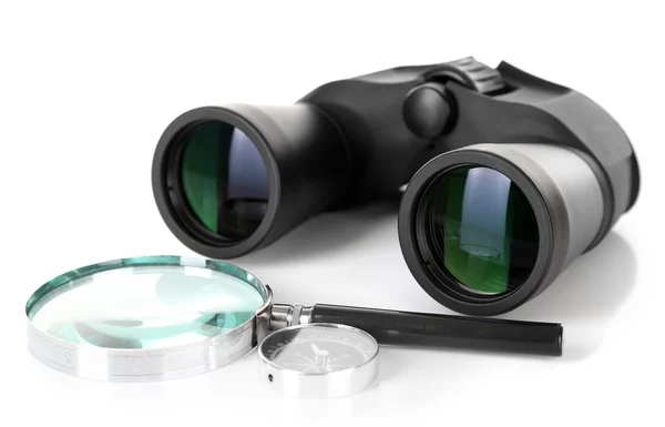 Black modern binoculars with magnifying glass and compass isolated on white — Stock Photo, Image