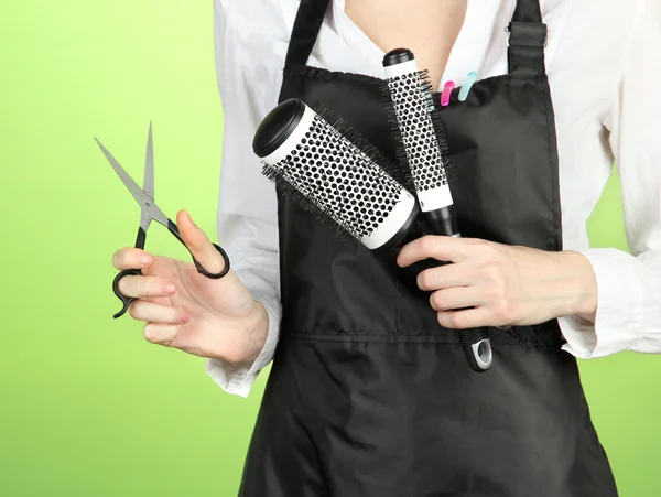 Hairdresser in uniform with working tools, on color background — Stock Photo, Image
