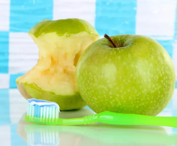 Appelen met een tandenborstel op plank in de badkamer — Stockfoto