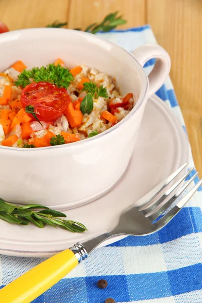 Delicious rice with vegetables and herbs in pot on wooden table close-up — Stock Photo, Image
