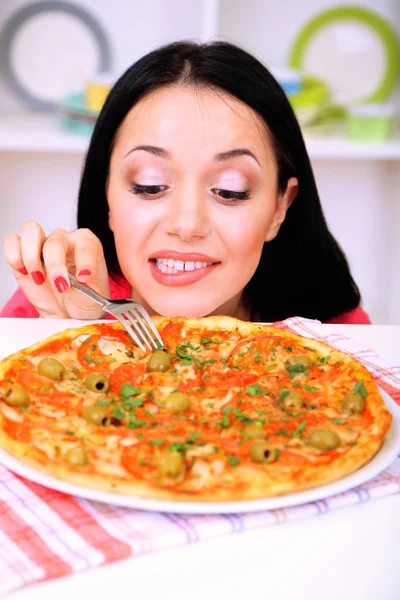 Hermosa chica quiere comer deliciosa pizza en fondo de cocina —  Fotos de Stock
