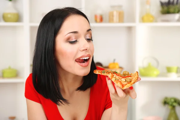 Hermosa chica quiere comer deliciosa pizza en fondo de cocina — Foto de Stock