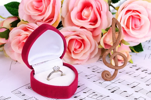 Houslový, růže a krabice snubní prsten na hudební pozadí — Stock fotografie