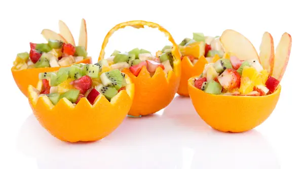 Ensalada de frutas en naranja ahuecada aislada sobre blanco — Foto de Stock