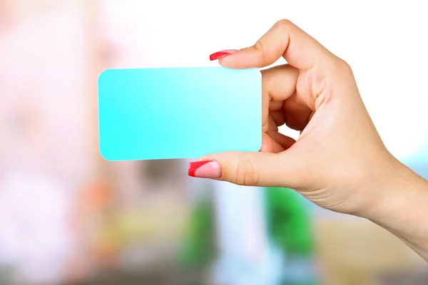 Tarjeta de mano femenina, sobre fondo brillante — Foto de Stock