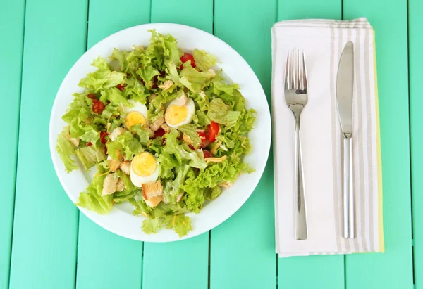 Ensalada César sobre plato blanco, sobre fondo de madera color —  Fotos de Stock