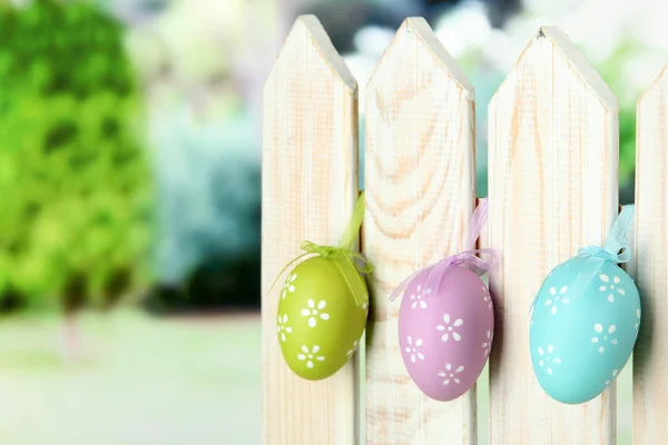 Art Easter background with eggs hanging on fence — Stock Photo, Image