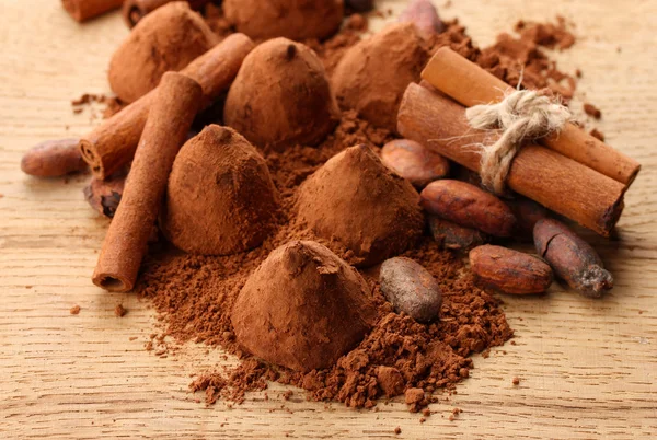Samenstelling van chocolade truffels, cacao en specerijen op houten achtergrond — Stockfoto