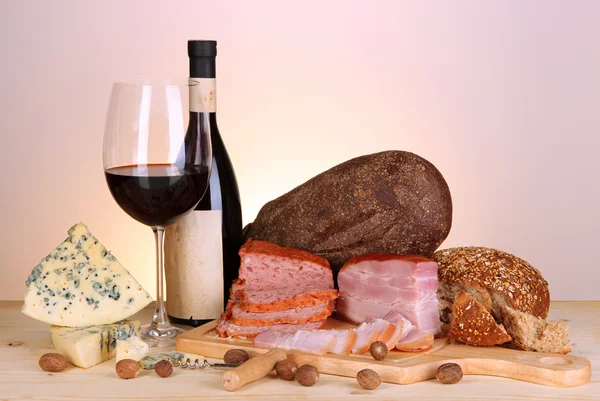 Exquisito bodegón de vino, queso y productos cárnicos — Foto de Stock