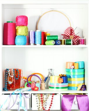 Beautiful white shelves with thread and material for handicrafts