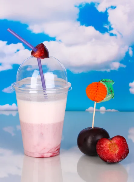 Delicioso batido de leche con fruta en la mesa sobre fondo azul marino — Foto de Stock