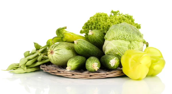 Verse groene groenten op rieten mat geïsoleerd op wit — Stockfoto