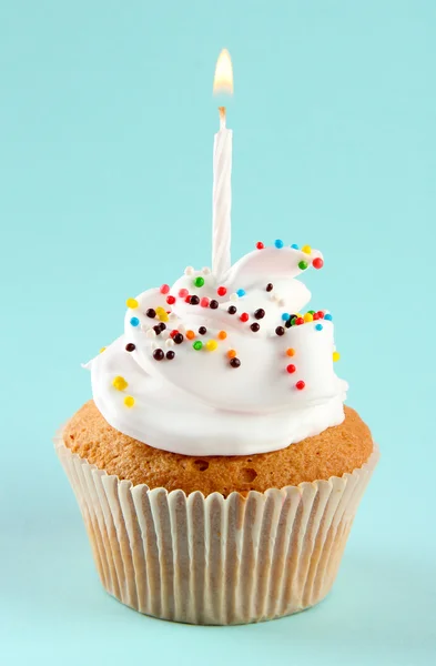 Cupcake de aniversário saboroso com vela, no fundo azul — Fotografia de Stock