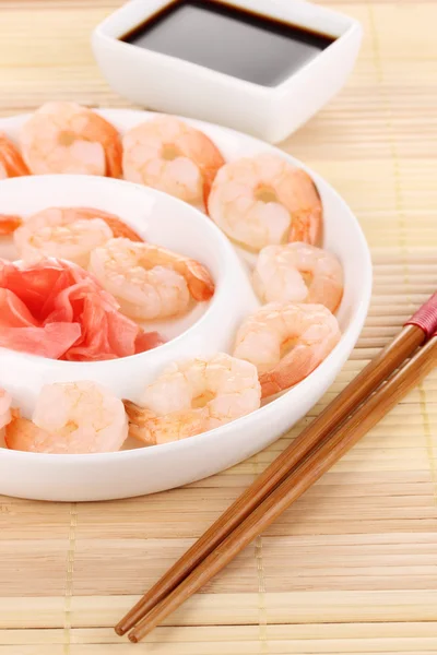 Langostinos en plato con palillos y salsa —  Fotos de Stock