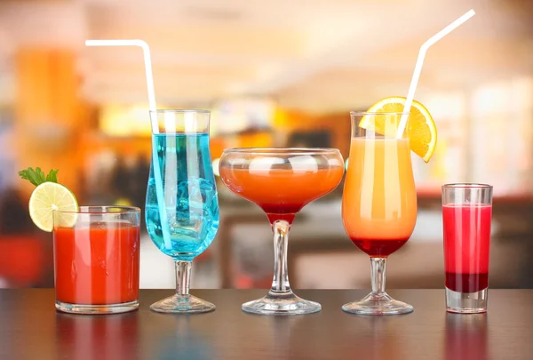 Several glasses of different drinks on bright background — Stock Photo, Image