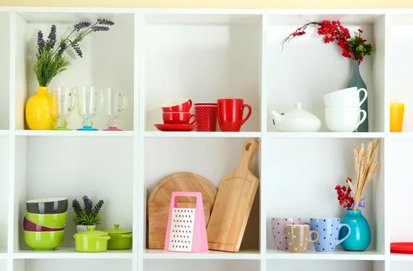 Beautiful white shelves with tableware and deco — Stock Photo, Image