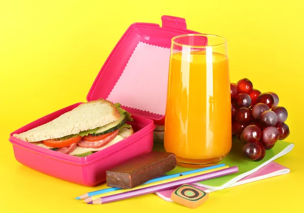 与三明治、 葡萄、 果汁和文具在黄色背景上的午餐盒 — 图库照片