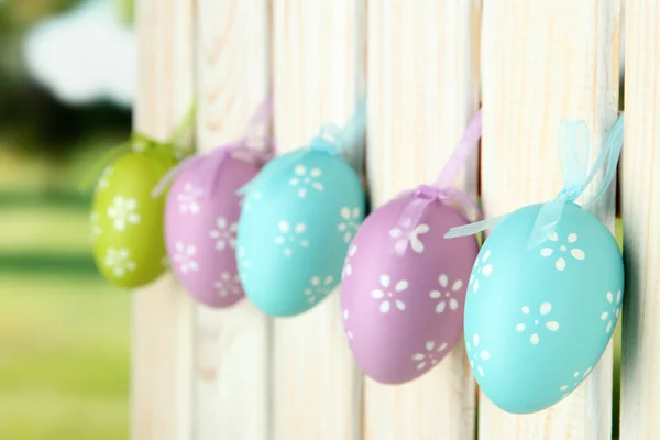 Art Easter background with eggs hanging on fence — Stock Photo, Image