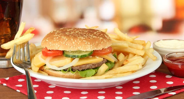 Смачний чізбургер зі смаженою картоплею та холодним напоєм на яскравому фоні — стокове фото