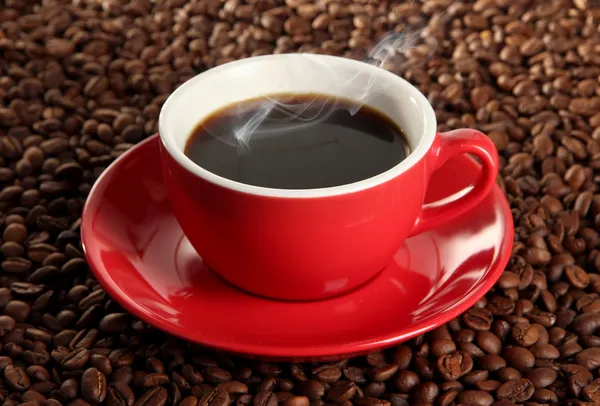 Cup of coffee on coffee beans background