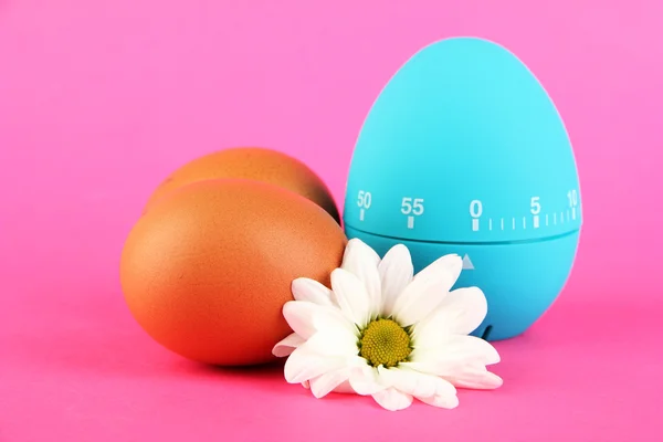 Blue egg timer and eggs, on color background — Stock Photo, Image