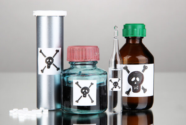 Смертельный яд в бутылках на сером фоне
