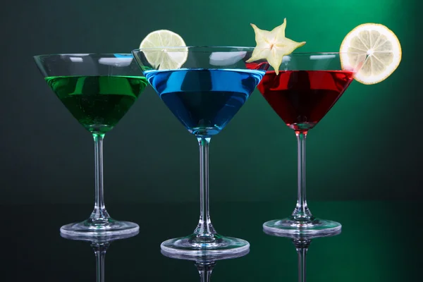 Cócteles alcohólicos en vasos de martini sobre fondo verde oscuro —  Fotos de Stock