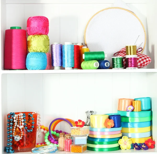 Beautiful white shelves with thread and material for handicrafts — Stock Photo, Image