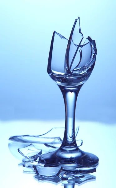 Zerbrochenes Weinglas auf blauem Hintergrund — Stockfoto