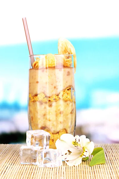 Delicioso batido de frutas en la mesa sobre fondo azul —  Fotos de Stock