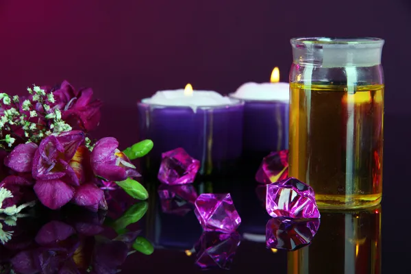 Spa oil and freesia on purple background — Stock Photo, Image