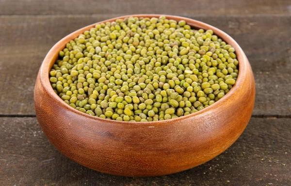 Haricots dans un bol sur fond en bois — Photo