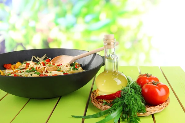 Fideos con verduras en wok sobre fondo de la naturaleza —  Fotos de Stock