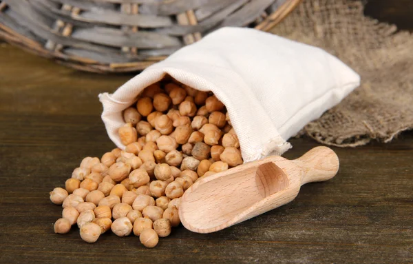 Beans in sack on wooden background — Stock Photo, Image