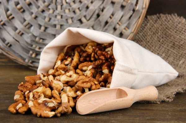 Nuts in sack on wooden background — Stock Photo, Image