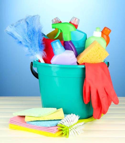 Schoonmaak items in emmer op kleur achtergrond — Stockfoto