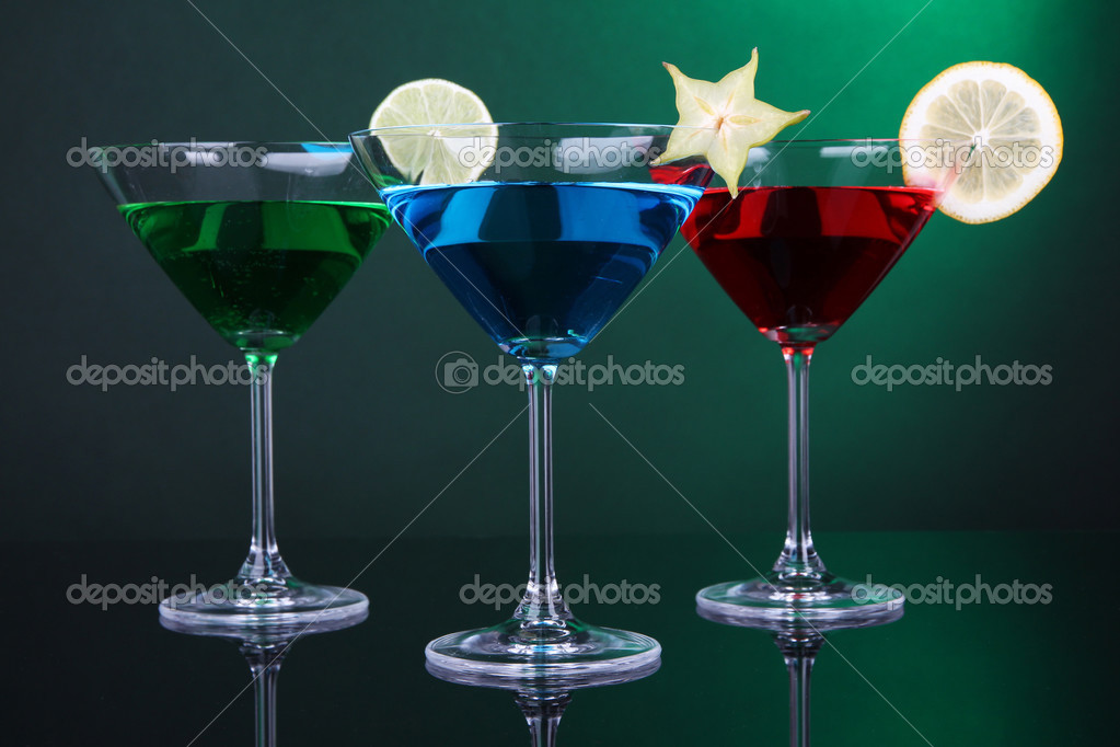 Alcoholic cocktails in martini glasses on dark green background Stock