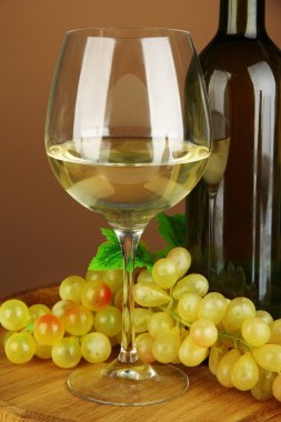 şişe şarap, beyaz şarap, üzüm, renkli arka plan üzerinde ahşap varil üzerinde kompozisyon