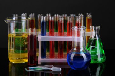 koyu arka plan üzerinde renkli test tüpleri